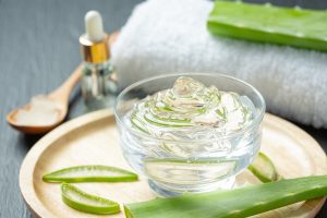 aloe vera gel in a bowl and slices of real aloe vera
